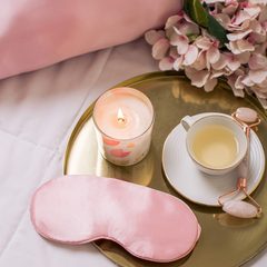 Masque de nuit posé sur un plateau, à côté d'une bougie